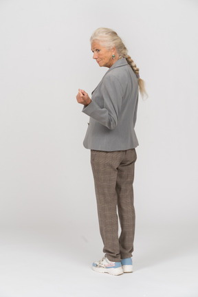 Rear view of an old lady in suit asking to come closer
