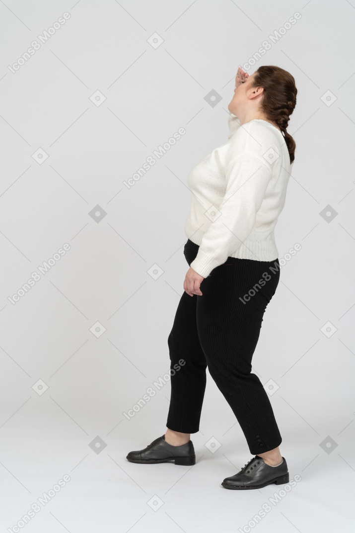 Vista lateral de la mujer de talla grande en ropa casual buscando a alguien