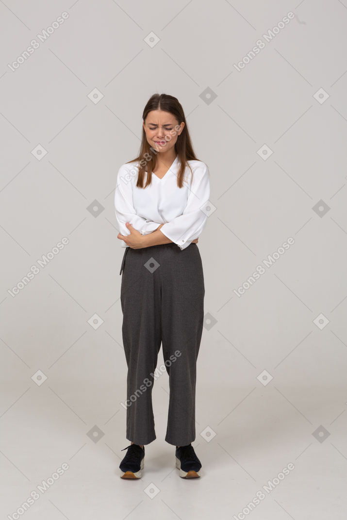 Front view of a displeased young lady in office crossing arms