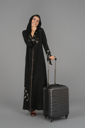 A smiling muslim woman travelling