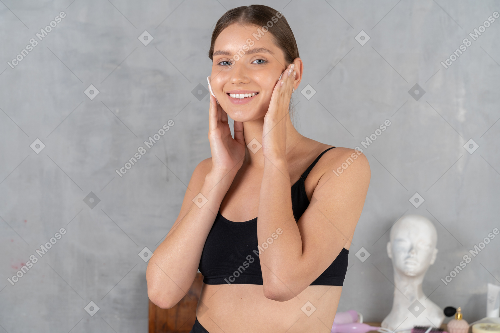 Smiling woman cleaning her face with cotton pads