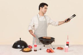 Joven hombre caucásico centrado en cocinar barbacoa