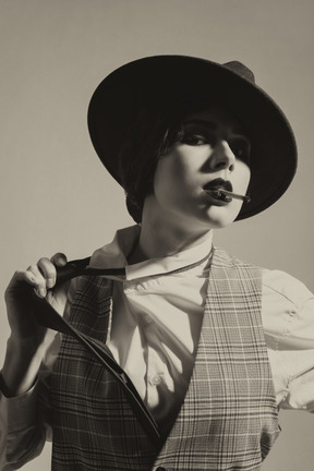 Mujer elegante en un sombrero quitando una corbata