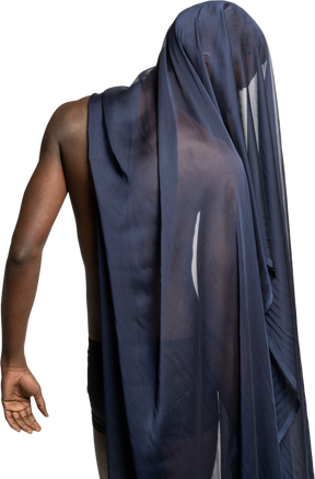 Back view of a young afro man covered with a dark blue shawl looking down