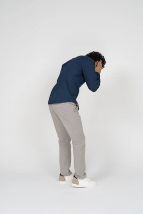 Side view of a man in casual clothes covering ears with hands