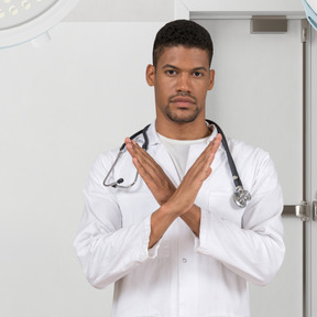 A man in a white lab coat with a stethoscope on his chest