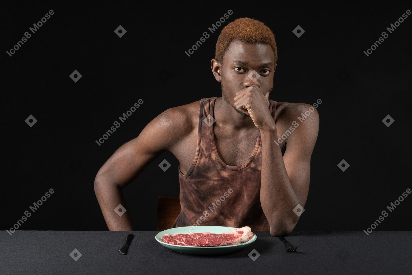 Front view of a thoughtful young afro man sitting at the table