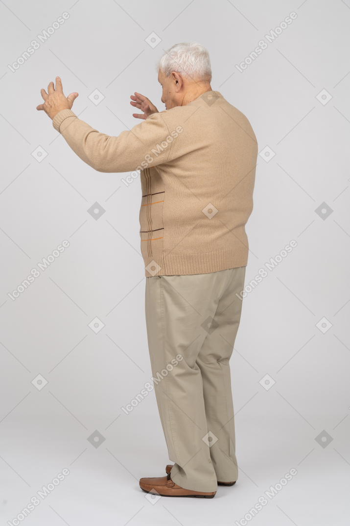 Seitenansicht eines alten mannes in freizeitkleidung, der die größe von etwas zeigt
