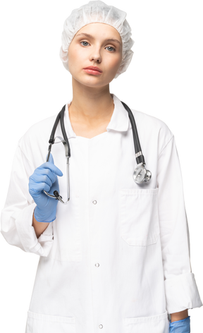 Vista frontal de una joven doctora sosteniendo estetoscopio