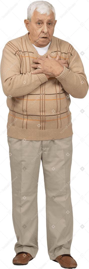 Vista frontal de un anciano asustado con ropa informal de pie con las manos en el pecho