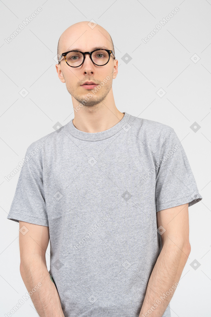 Bald man in gray t-shirt looking at the camera