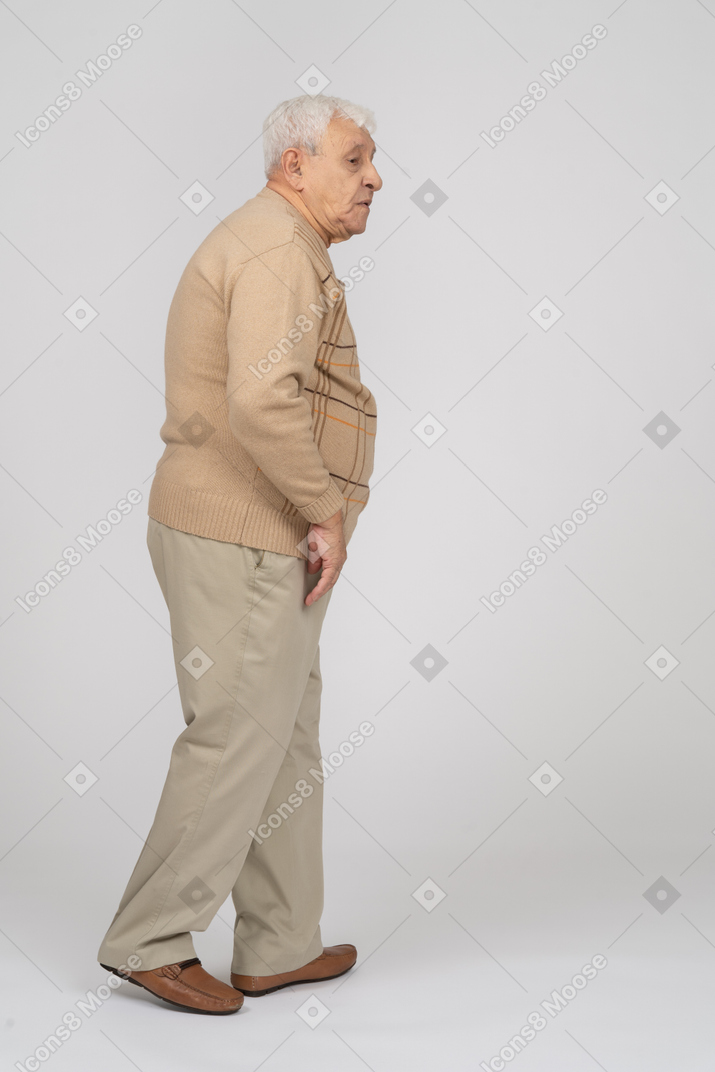 一位穿着休闲服走路的老人的侧视图