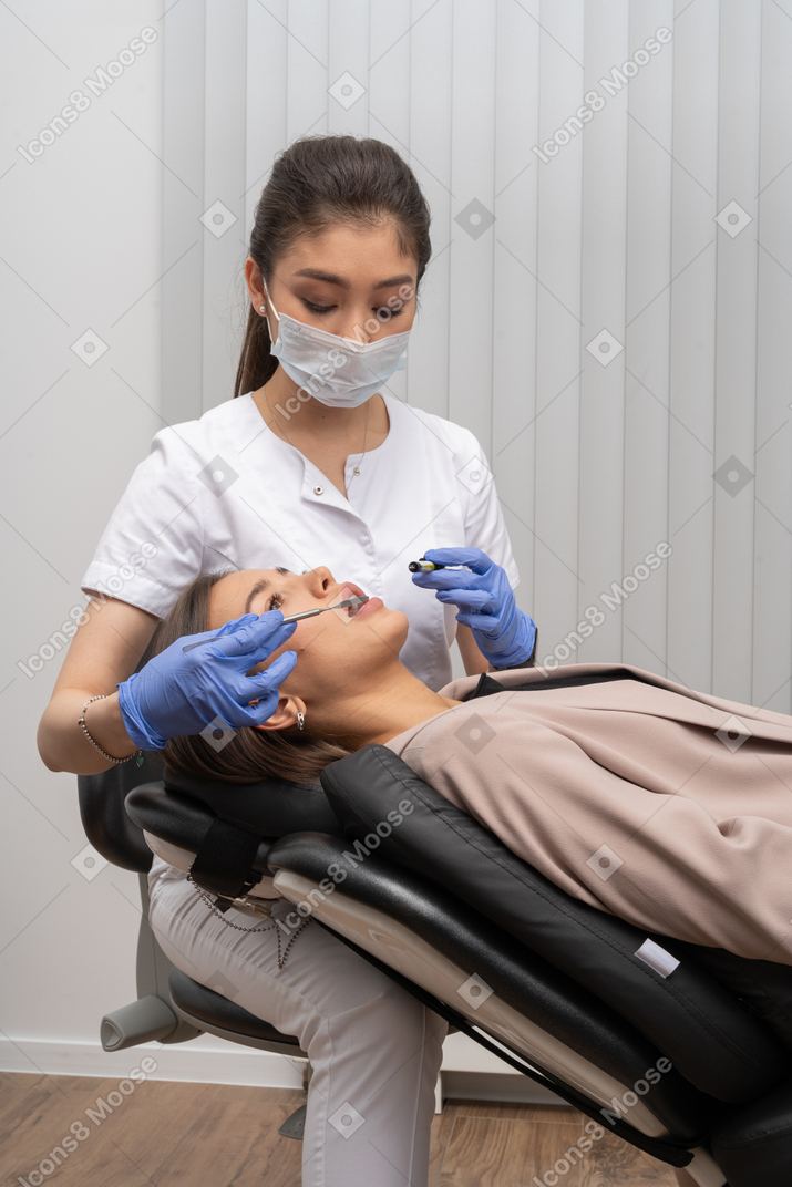 Female dentist in mask and latex gloves  getting ready for surgery