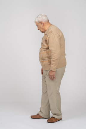 カジュアルな服装で見下ろしている老人の側面図