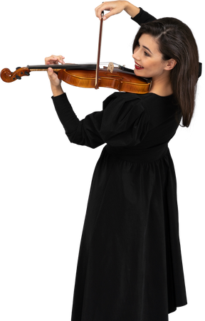 Крупный план молодой веселой дамы в черном платье, играющей на скрипке