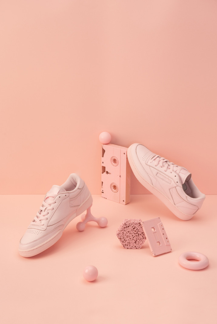 Pink sneakers, tapes and some other objects on the pink background