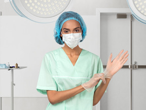A woman wearing a surgical mask and gloves