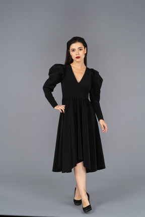 Vue frontale, de, a, jeune femme, dans, a, robe noire, mettre, main, hanche