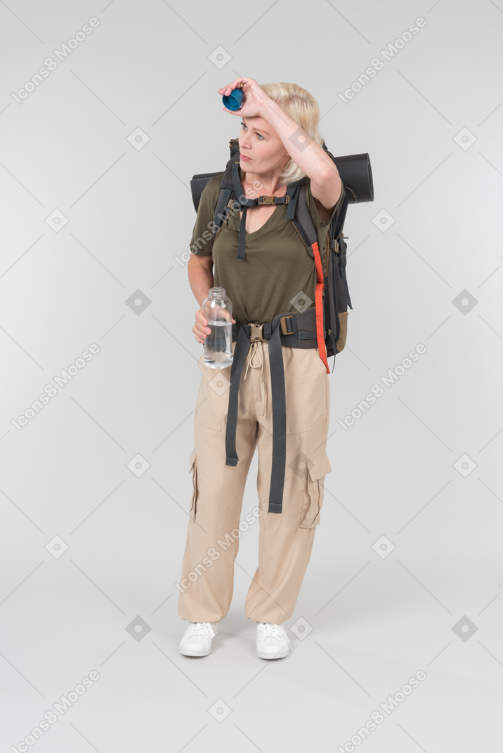 Mature male tourist carrying backpack and drinking water