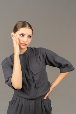 Front view of a young woman in a jumpsuit removing make-up