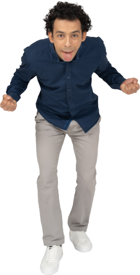 Vista frontal de um homem com roupas casuais mostrando a língua e gesticulando