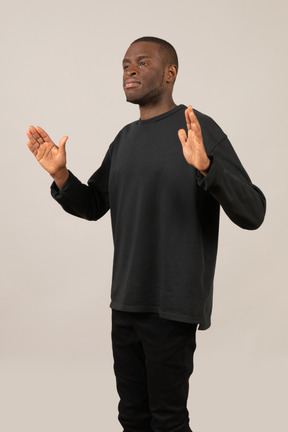Young man standing with raised hands