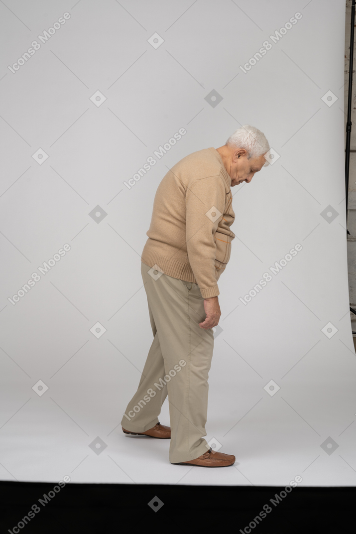 Vue latérale d'un vieil homme en vêtements décontractés marchant