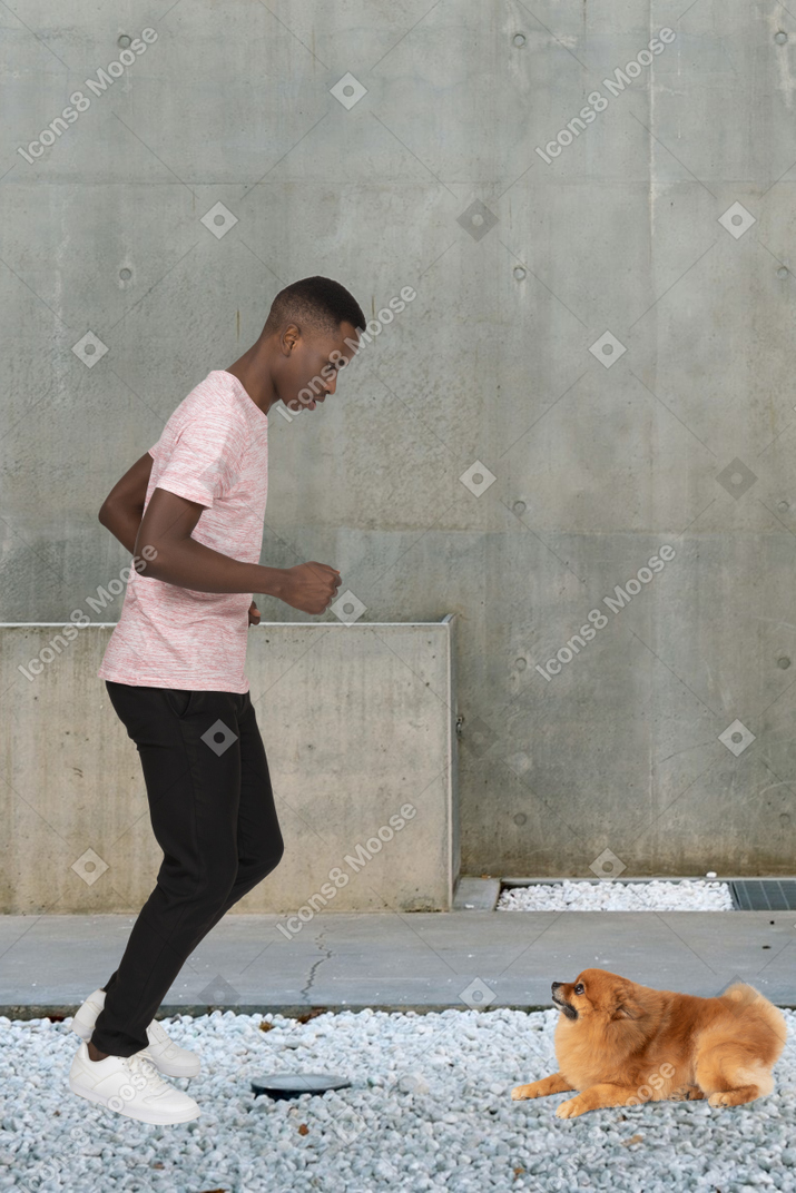 A man running with a dog in front of him