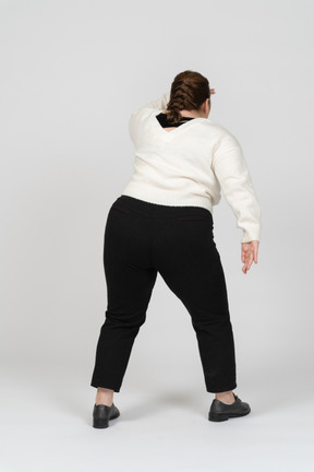 Rear view of plump woman in casual clothes looking for someone