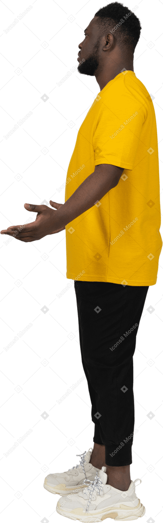 노란색 티셔츠를 입은 검은 피부가 불쾌한 젊은 남자의 옆모습