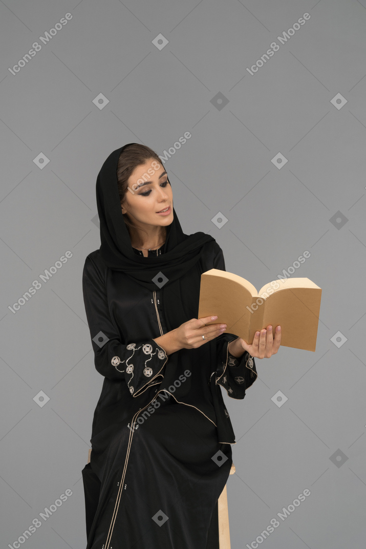 A young muslim woman sitting with a book