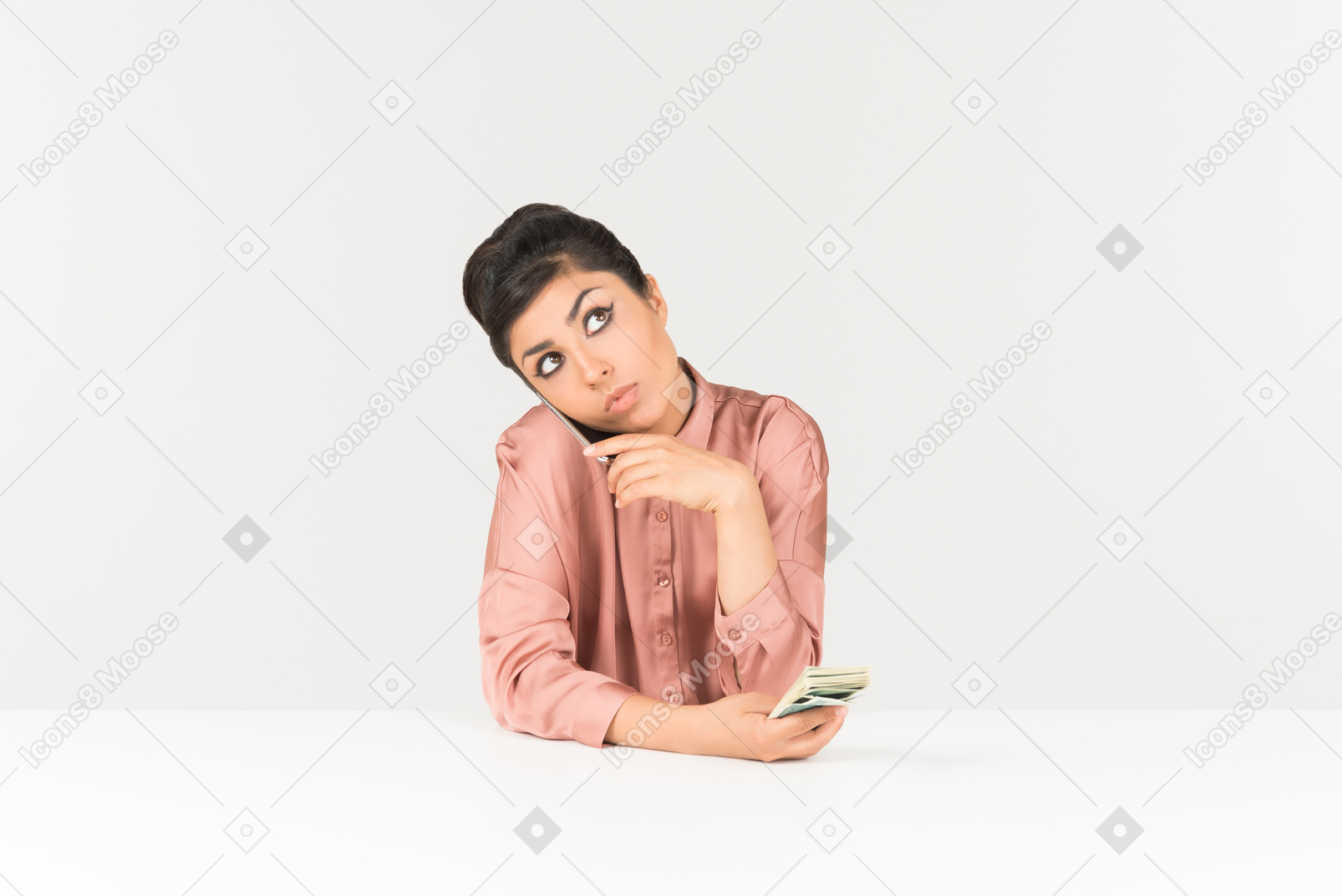 Young indian woman holding money bills and talking on the phone