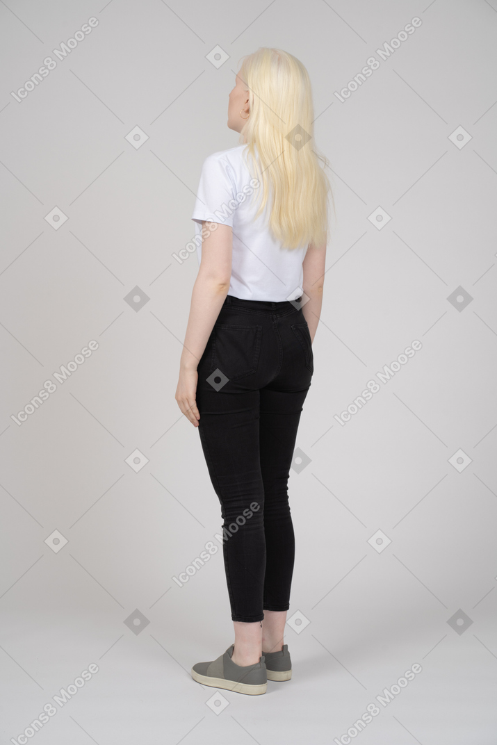 Vista posteriore di una giovane ragazza bionda in piedi
