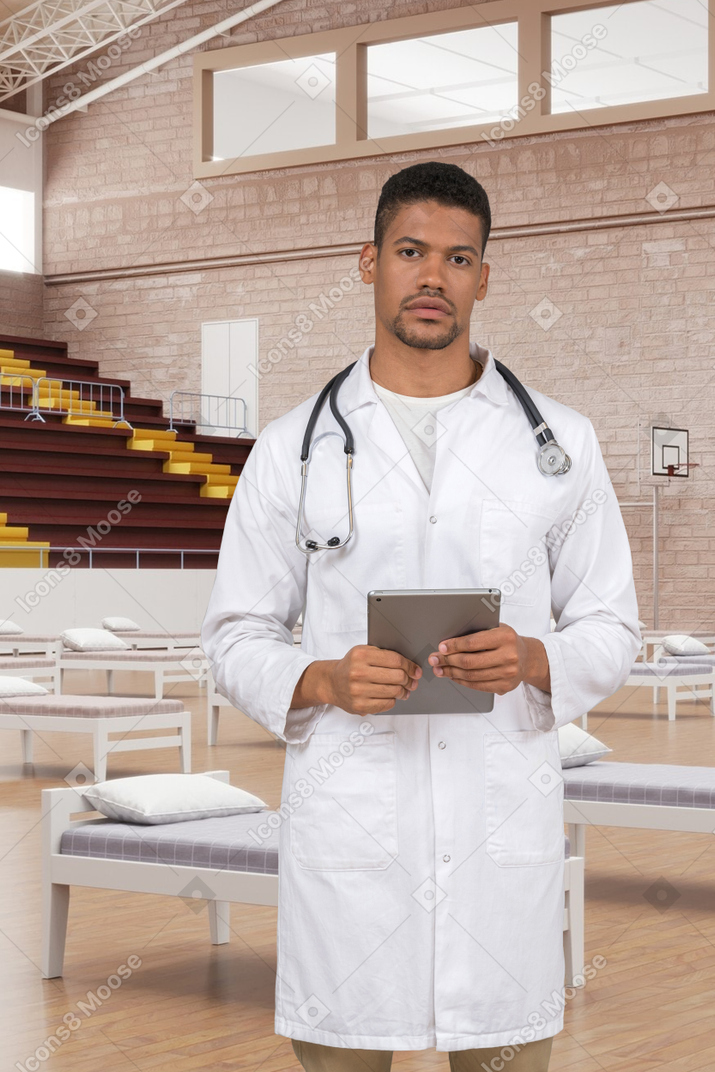 A man in a white lab coat holding a tablet