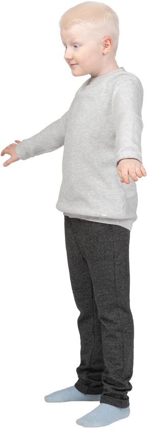 Vista de tres cuartos de un niño con las manos ligeramente levantadas