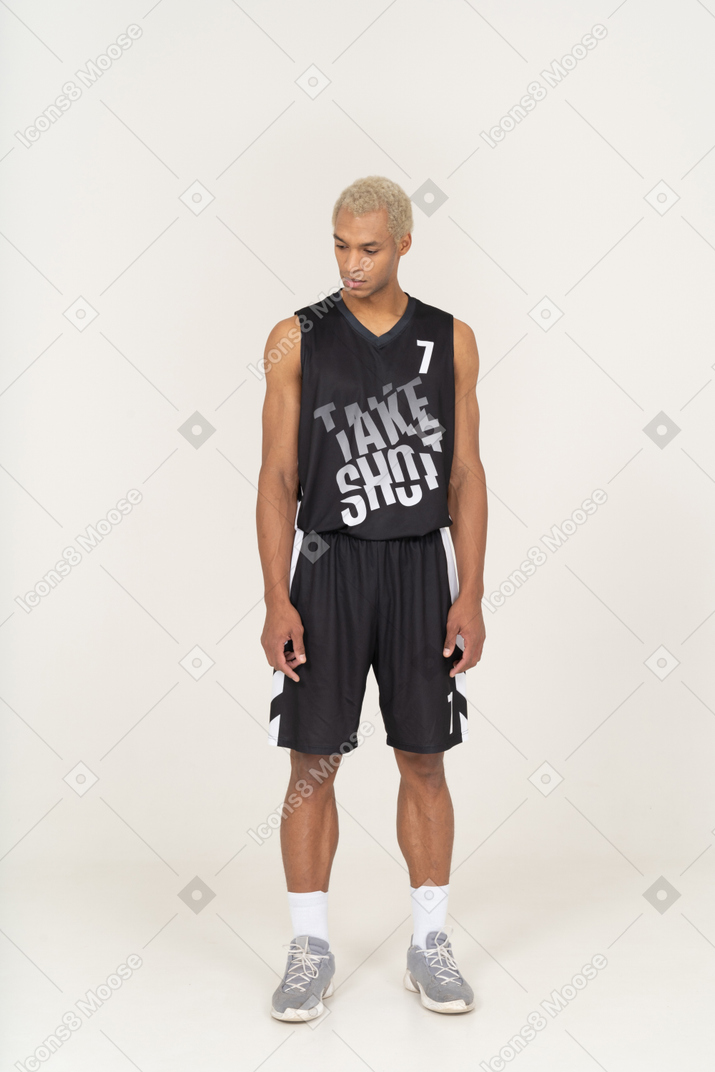 一个年轻的男篮球运动员站着不动俯视的前视图