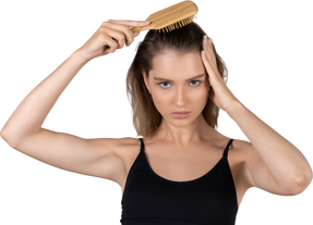 Front view of a young woman brushing her hair