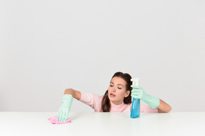 Attractive young woman dusting a surface