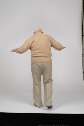Vista trasera de un anciano con ropa informal caminando
