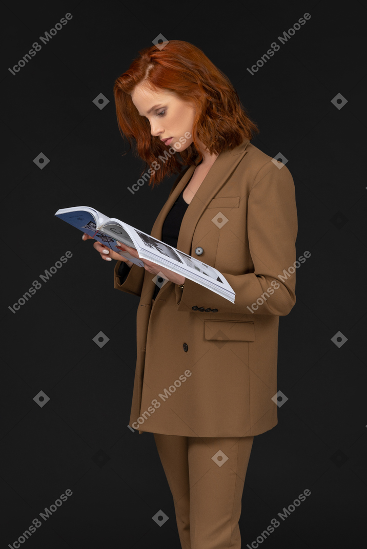 Side view of a young businesswoman reading a magazine