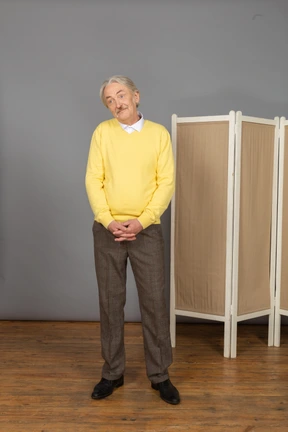 Front view of a shy smiling old man looking aside