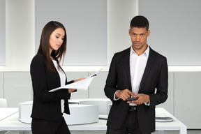 A man and a woman standing next to each other in an office