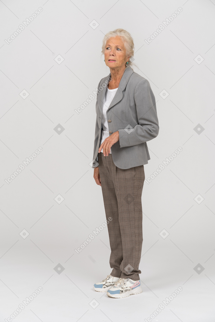 Vecchia signora in abito in piedi di profilo