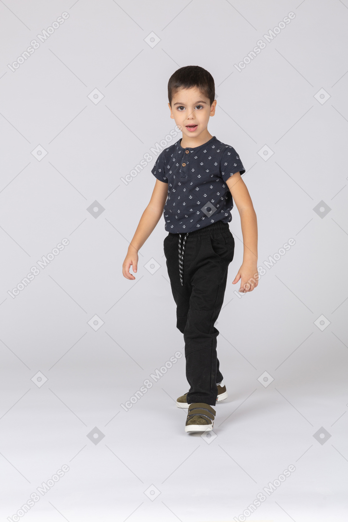 Vista frontal de un chico lindo caminando hacia adelante