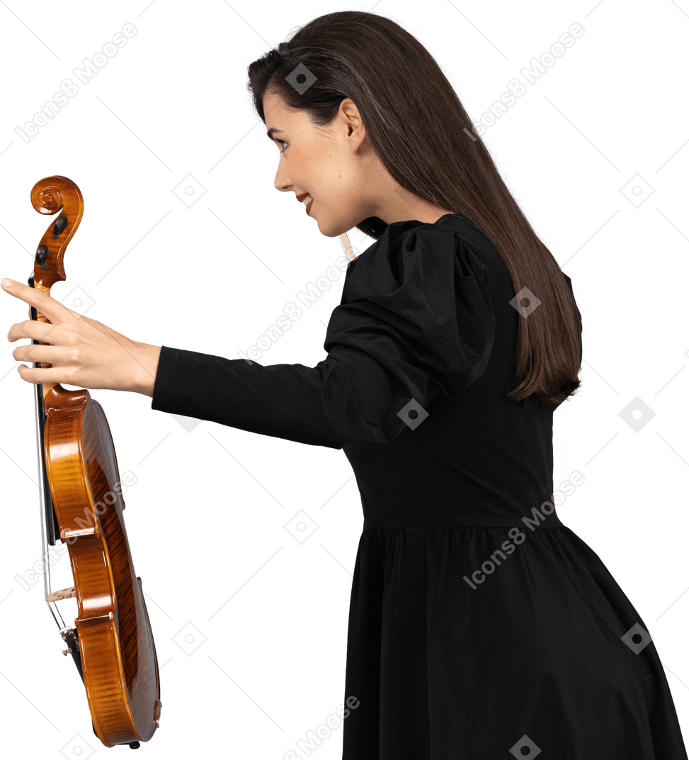 Side view of a female violin player in black dress making a bow