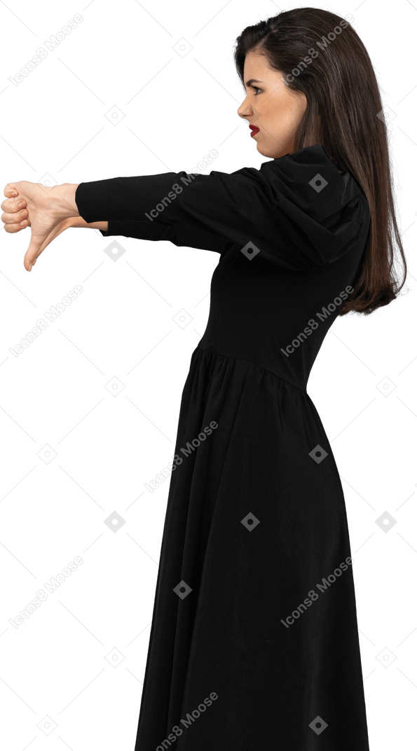 Side view of a displeased young lady in black dress putting thumbs down