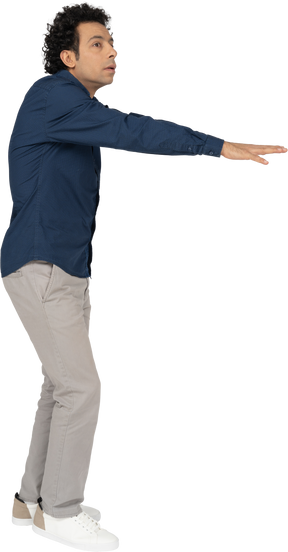 Vista lateral de um homem com roupas casuais em pé com os braços estendidos