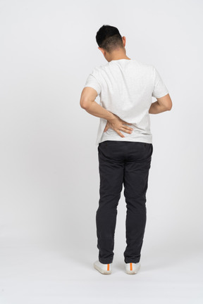 Vista trasera de un hombre con ropa informal que sufre de dolor de espalda