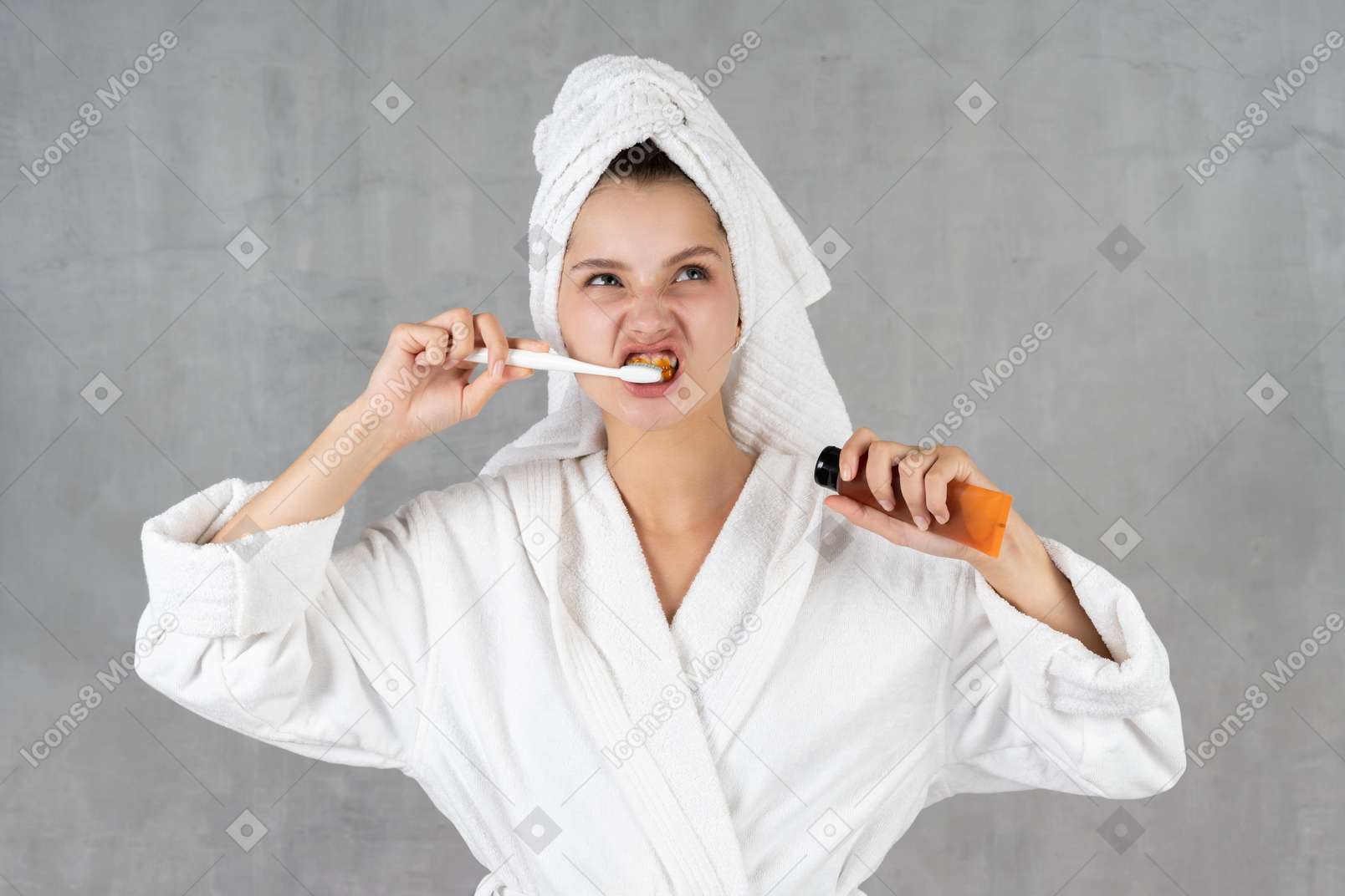 Frau im bademantel grimassen beim zähneputzen