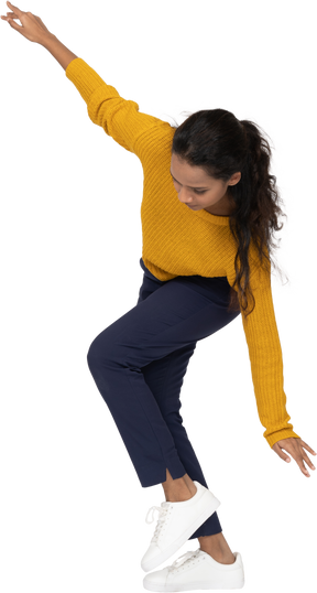 Side view of a girl in casual clothes bending down with outstretched arms